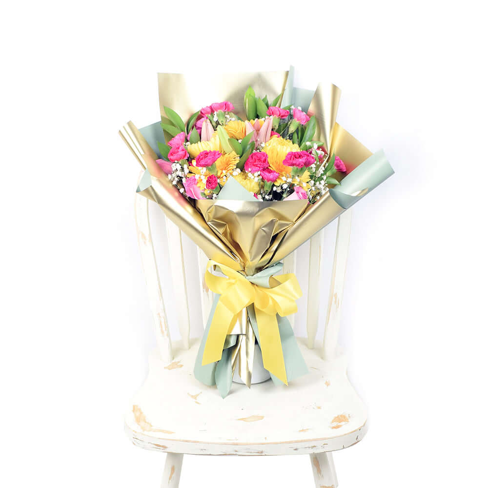 Exotic Eden Mixed Floral Bouquet. Mini carnations, tulips, roses, lilies, chrysanthemums, baby's breath, ruscsus in shades of pink and yellow, gathered in a floral wrap tied with designer ribbon. Mixed Floral Gifts from Monthly Sommelier USA - Same Day USA Delivery.